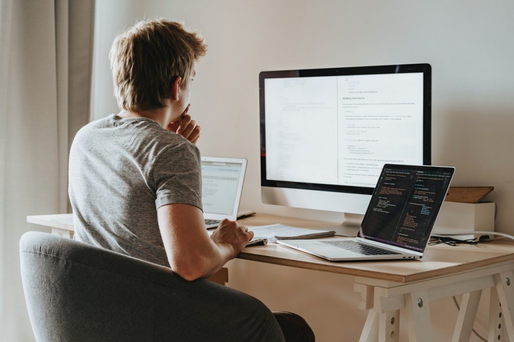 a-man-thinking-in-front-of-the-computer-and-laptops