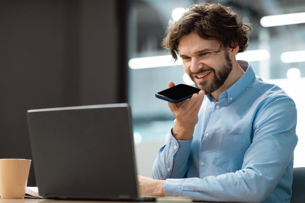 Smiling man working and talking on phone at office