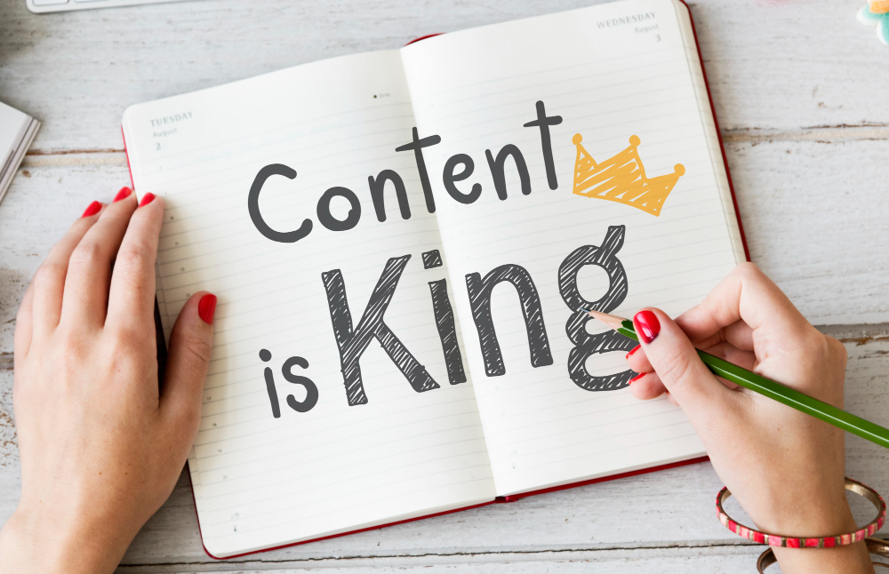 Woman writing content is king on a notebook