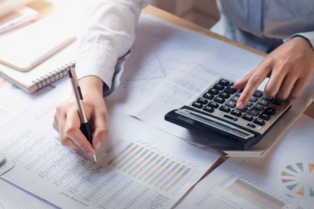 Business Woman Working on Desk Using Calculator