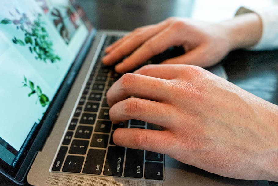 A Man Is Typing on a Laptop’s Keyboard